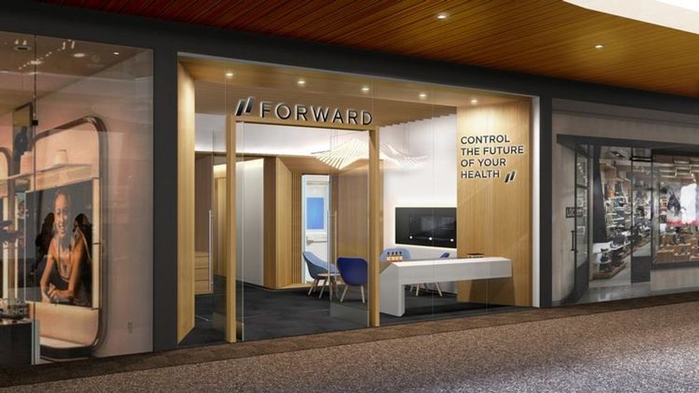 A storefront with blind wood, desks and chairs that says "Forward" over the doorway