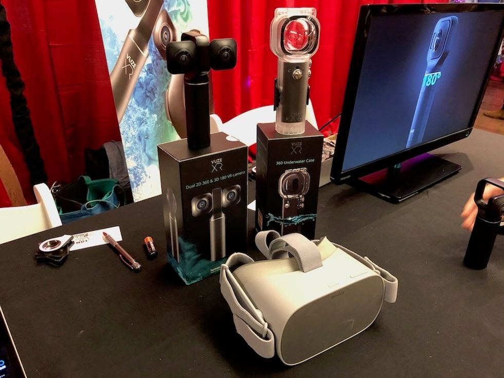 A VR handheld camera and white headset on a table at a convention
