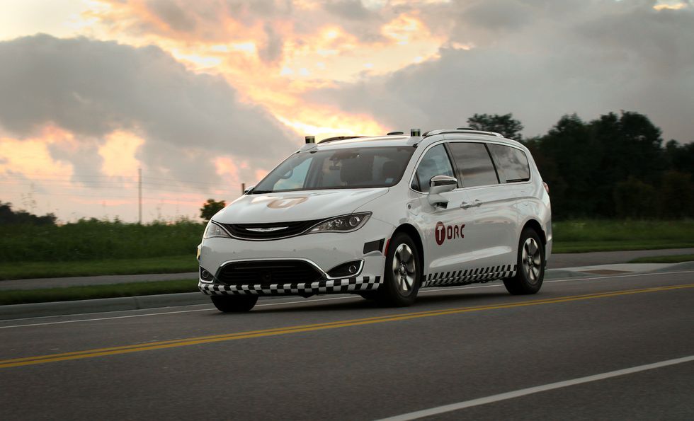 A white car with sensors on it, and the word 'Torc' on the front and side