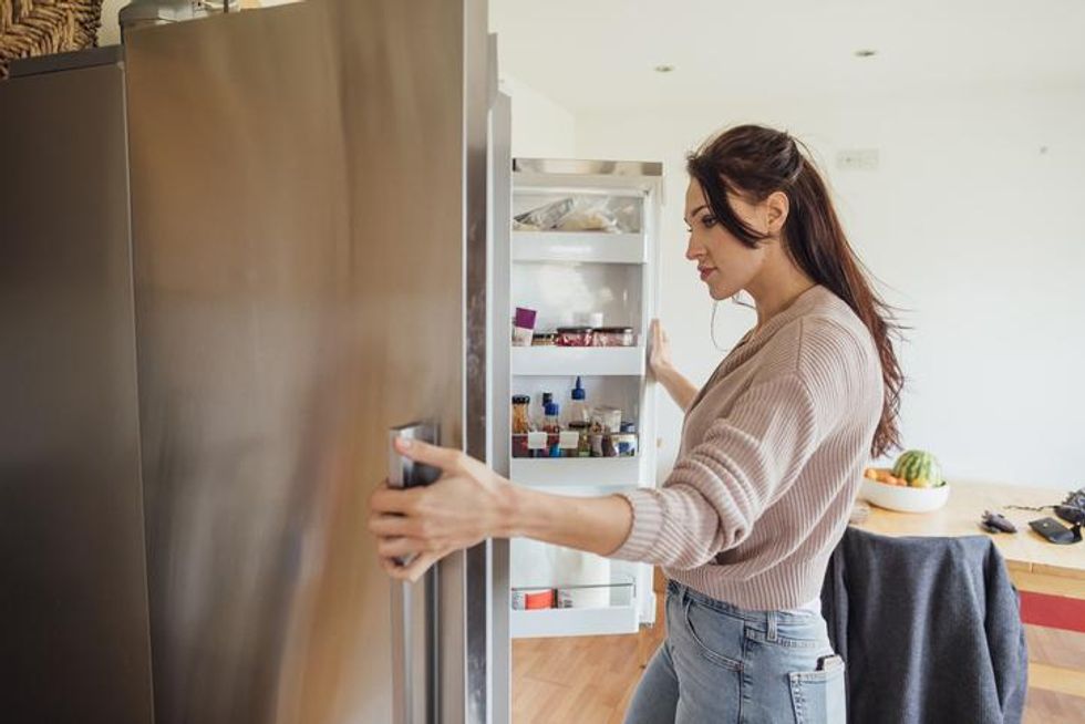 A woman opening a refrigerator
