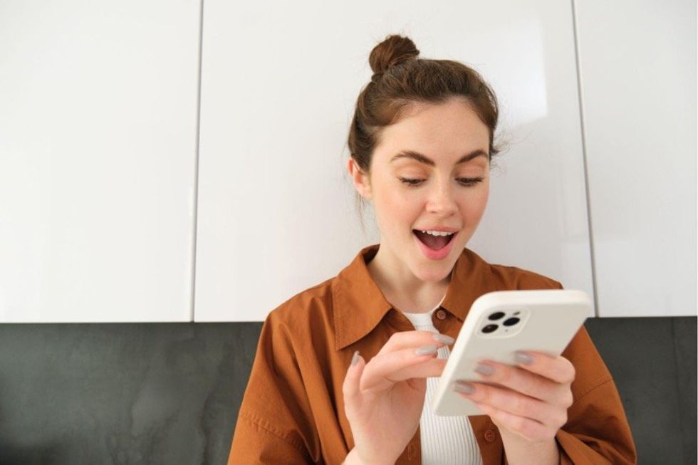 a woman playing Solitaire on her smartphone