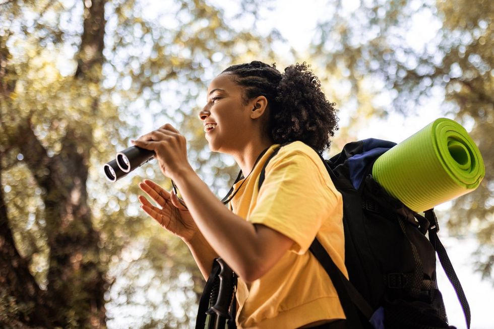 a woman using binoculars on a hike