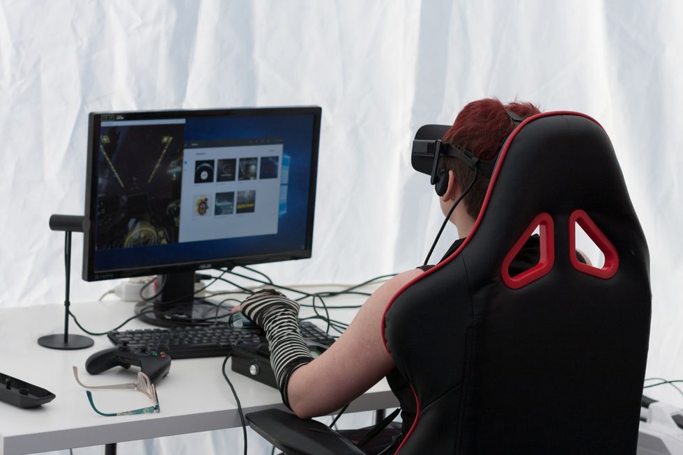 a woman using VR Headset thethered to her computer.