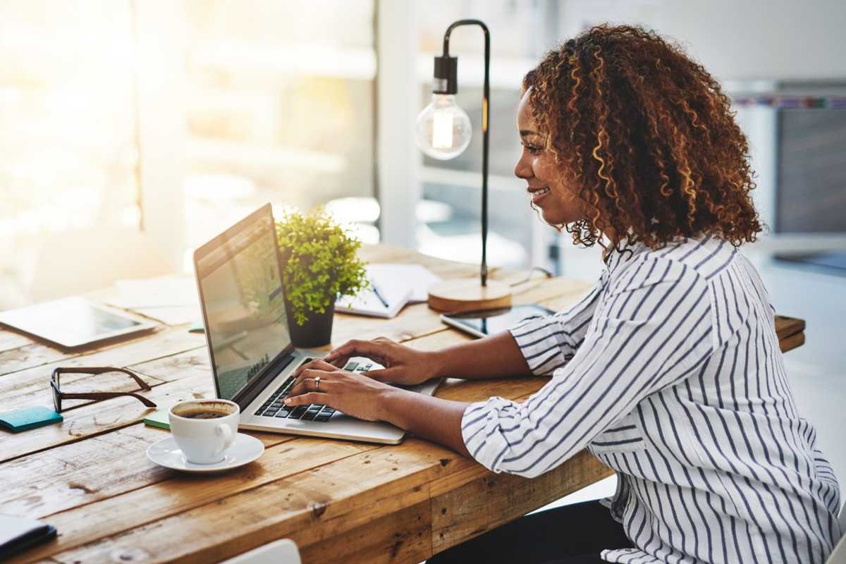a woman working on a laptop in her home.
