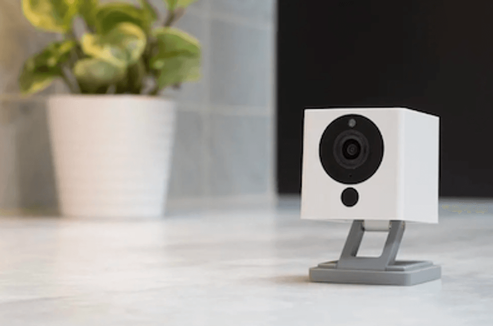 A WyzeCam camera in white with a gray stand