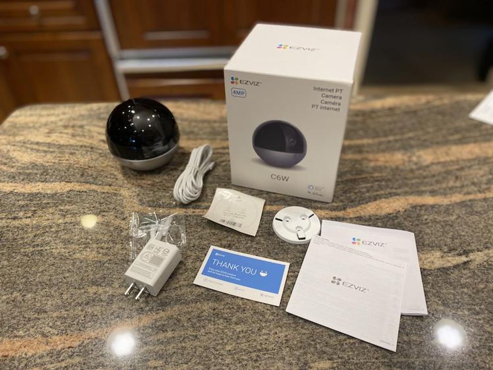 All the parts found in Ezviz C6W camera box on a countertop