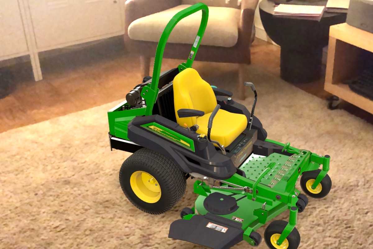 An image of a green and yellow John Deere lawn mower in the middle of a living room