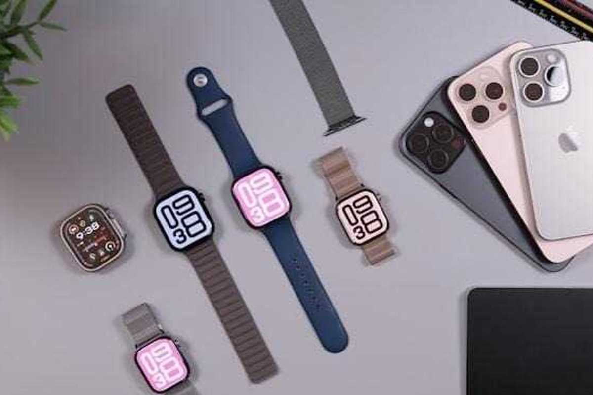 Apple watches and iphones arranged on a desk.