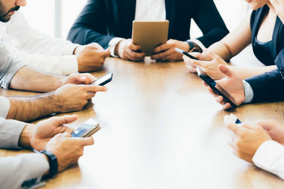Business men and woman are using phone on desk inside office space photo