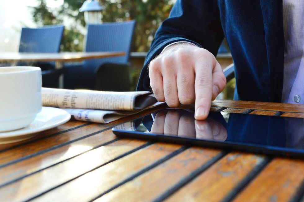 Businessman using digital tablet in an outdoor restaurant.