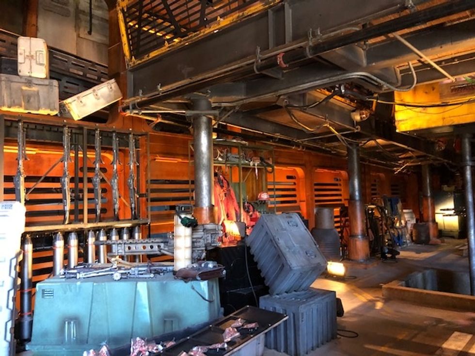 Cases and boxes with mechanics tools lying on top of them, surrounded by pipes and metal stairways