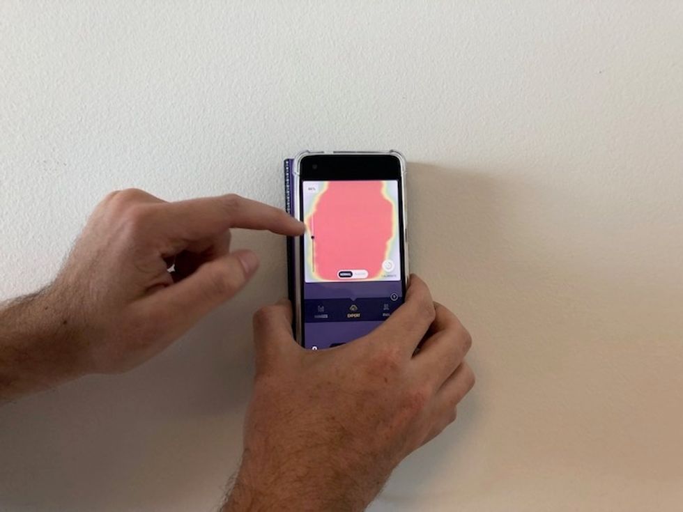 Connecting to an Android smartphone, the Walabot DIY Plus, pictured at work here, displays raw data giving professionals more clues of what's behind a wall