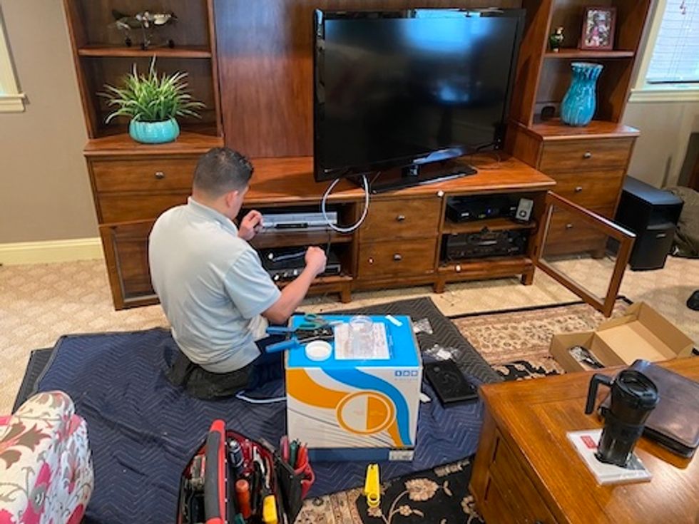 Control4 installer attaching IR reader to older consumer electronics.