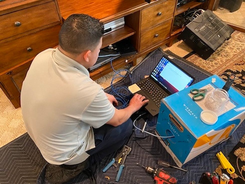 Control4 installer setting up devices on a comper