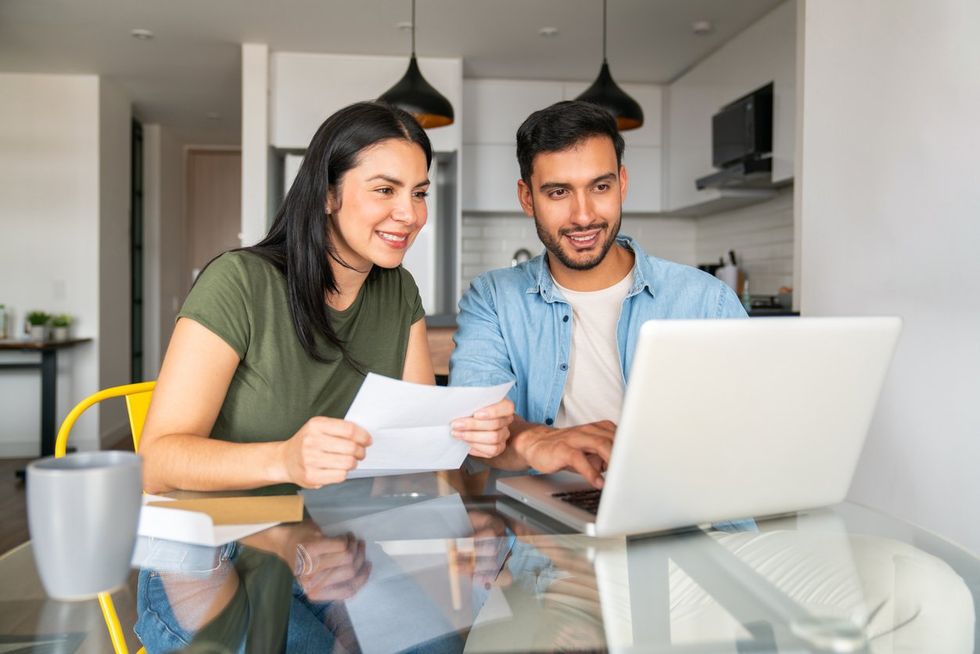 Couple paying utility bills at home using their laptop stock photo