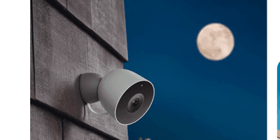 photo of Google Nest Cam 2nd Gen on a home at night with moon showing in the sky.