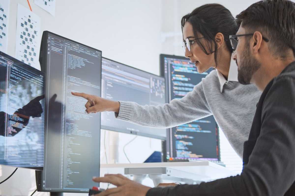 Hispanic Latin American couple, software engineer developer use computer, work on program coding together at home office. Programming language development technology, freelance job concept stock photo