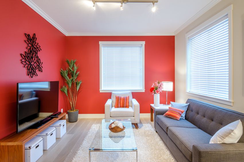 a neat and tidy living room with red walls