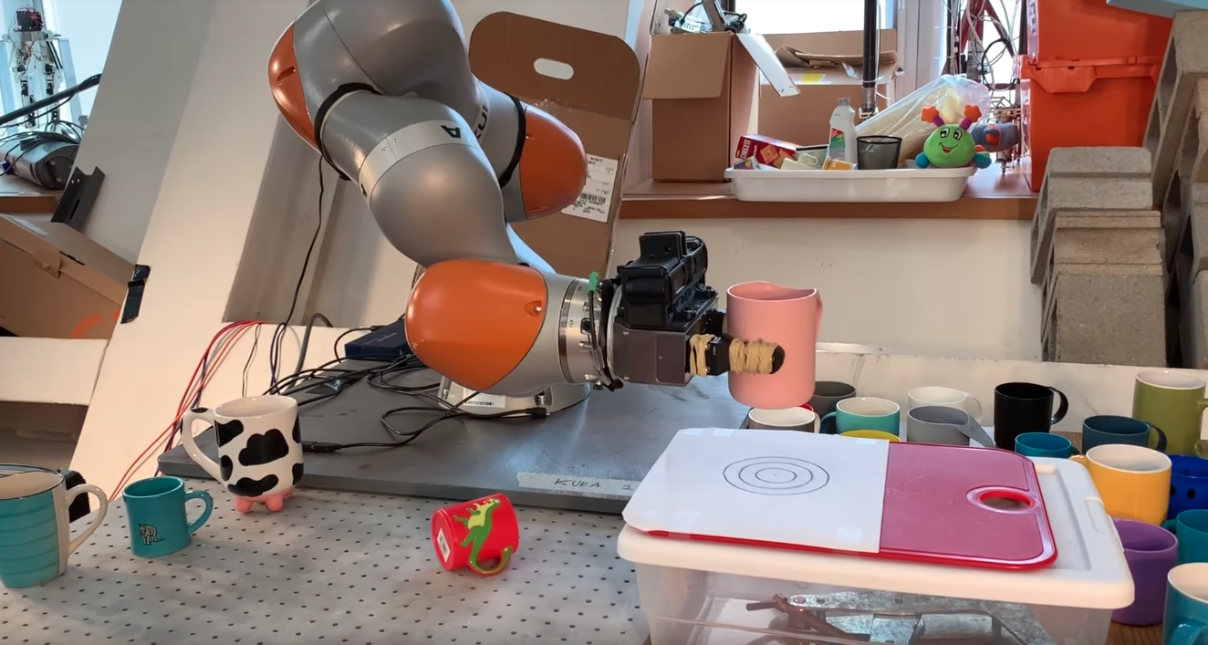 Screenshot of a video showing an MIT robot picking up a mug