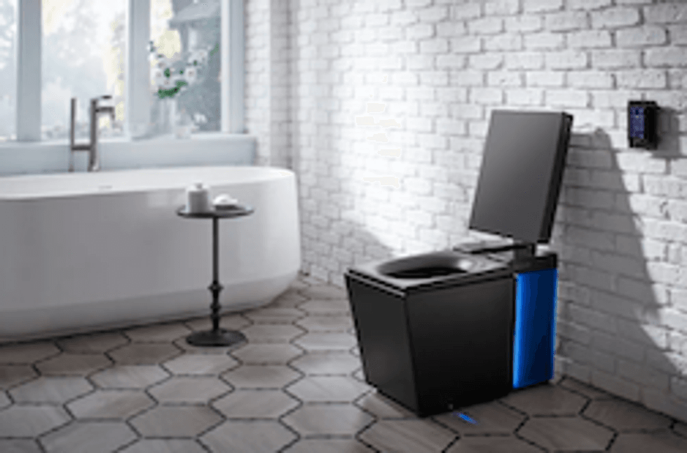 Kohler toilet in a white tiled bathroom