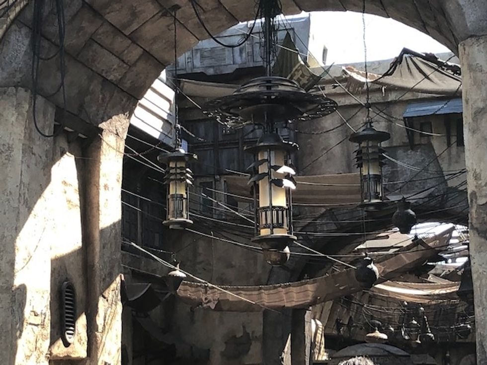 Lanterns, tarps and lights that hand from an open air market in Galaxy's Edge in browns and grays
