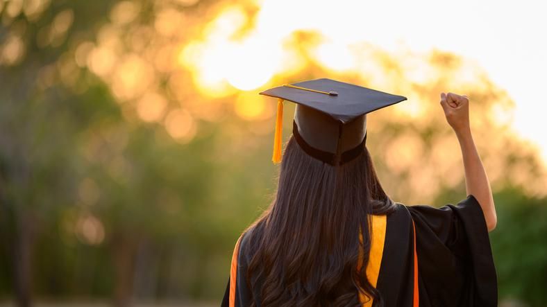 A new graduate wearing a cap and gown