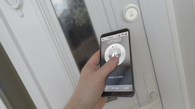 a person using smartphone and app to unlock a smart door lock.