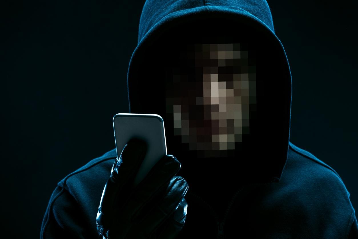 a photo of a hacker with a smartphone