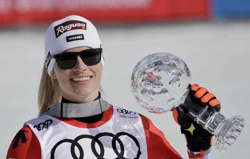 photo of Lara Gut-Behrami holding a trophy on the ski slopes