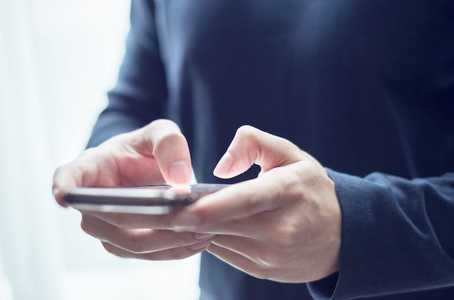 A person holding a smartphone and typing