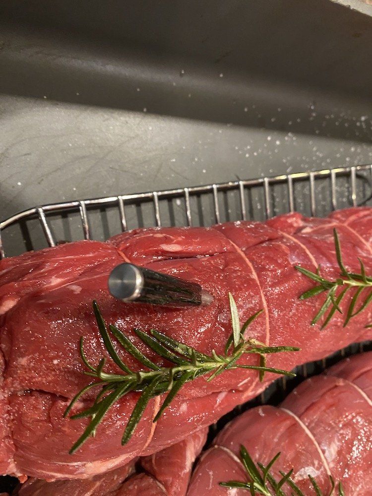 A photo of a smart meat thermometer inserted into a filet.
