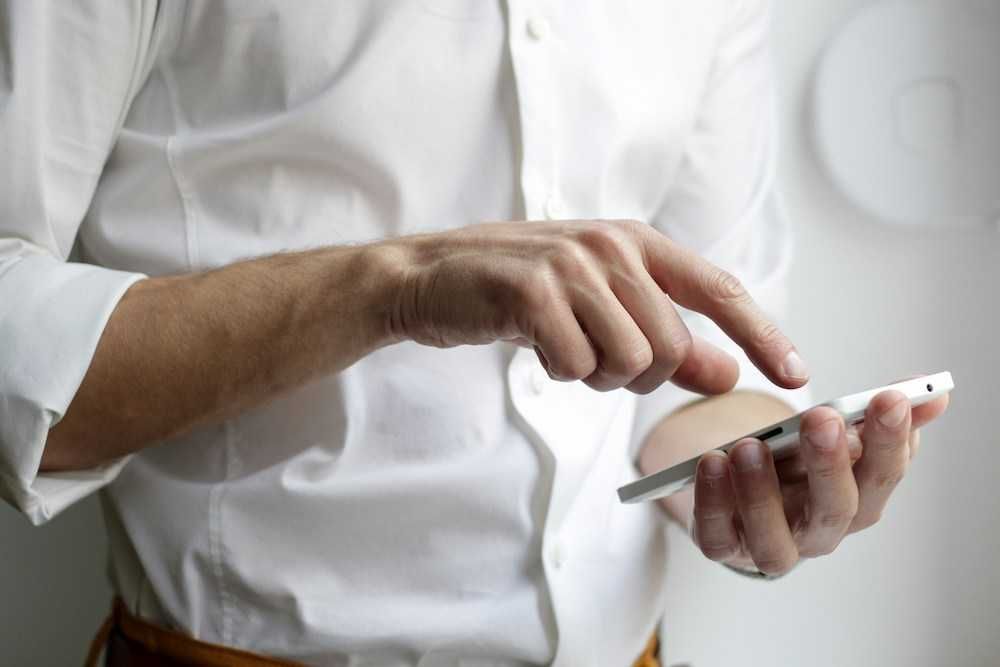 photo of person holding white Android smartphone in white shirt