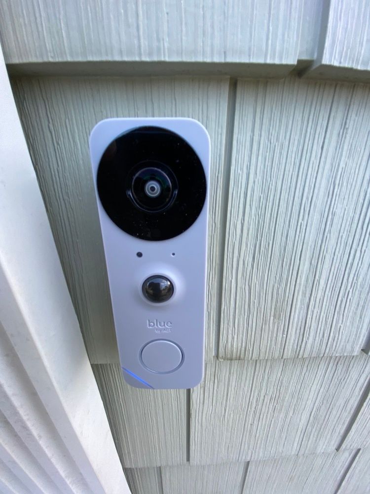 The Blue Doorbell Camera on the side of the house next to the front door.