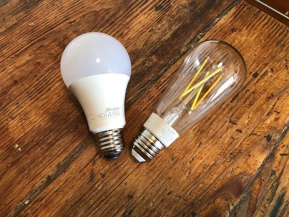 Two smart light bulbs, one standard and one with filament visible