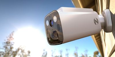 a photo of Night Owl's New Solar-Powered Security Camera on a home with a family playing in the yard.