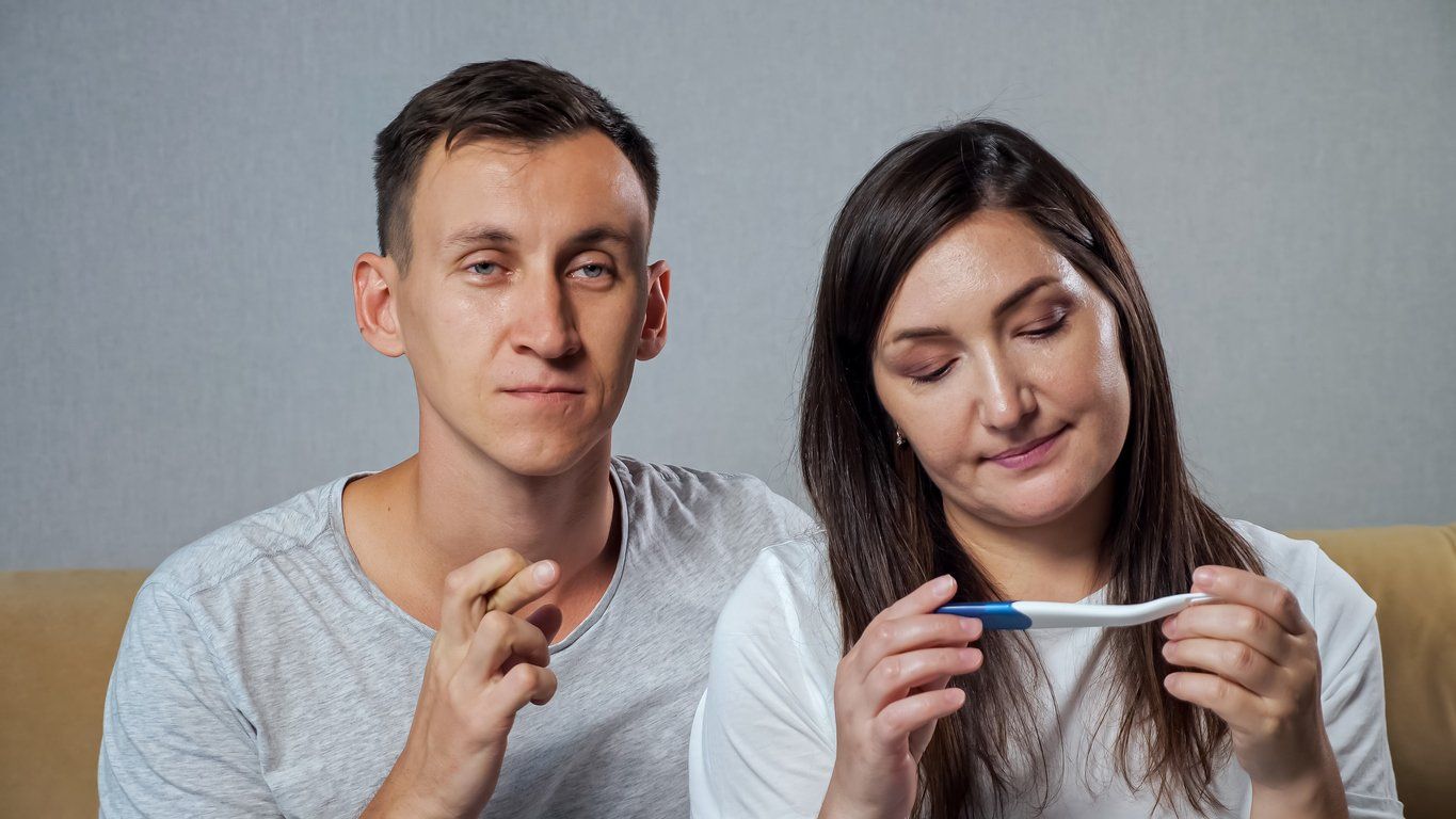 a man and woman waiting to see if the pregnancy test is positive or negative.