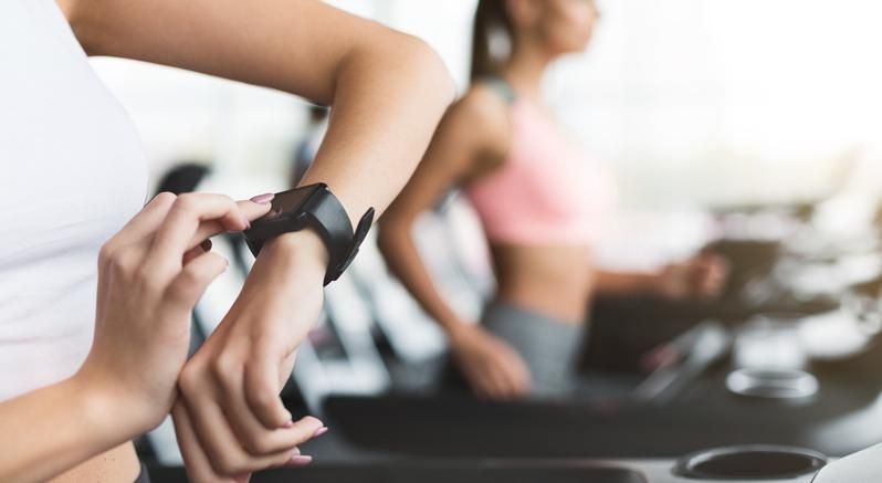 A person with a smartwatch on their arm in the gym