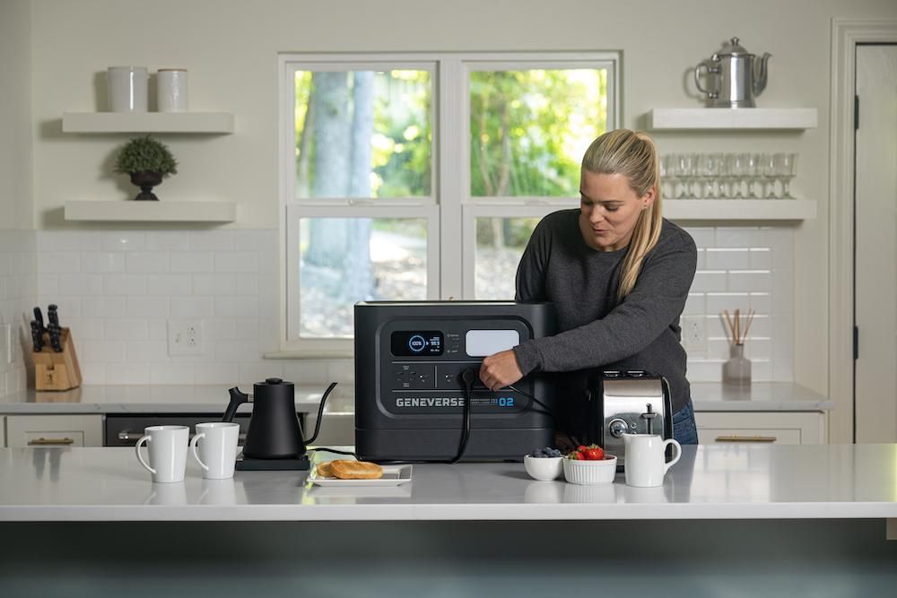 a photo of a woman using Geneverse Solar powered generator in her kitchen