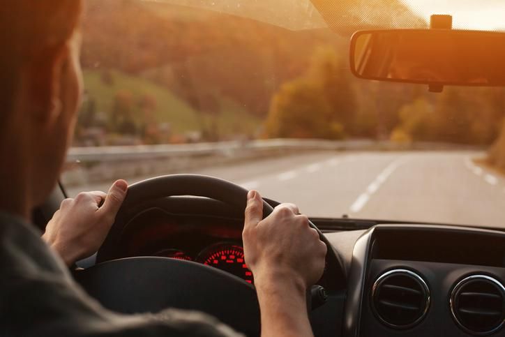 A person with their hands on the wheel in a car