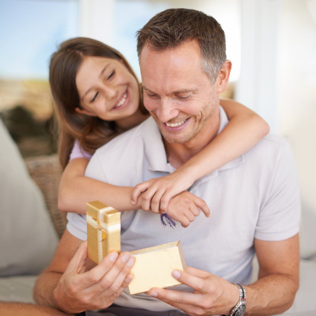 a dad opening a gift from his daughter