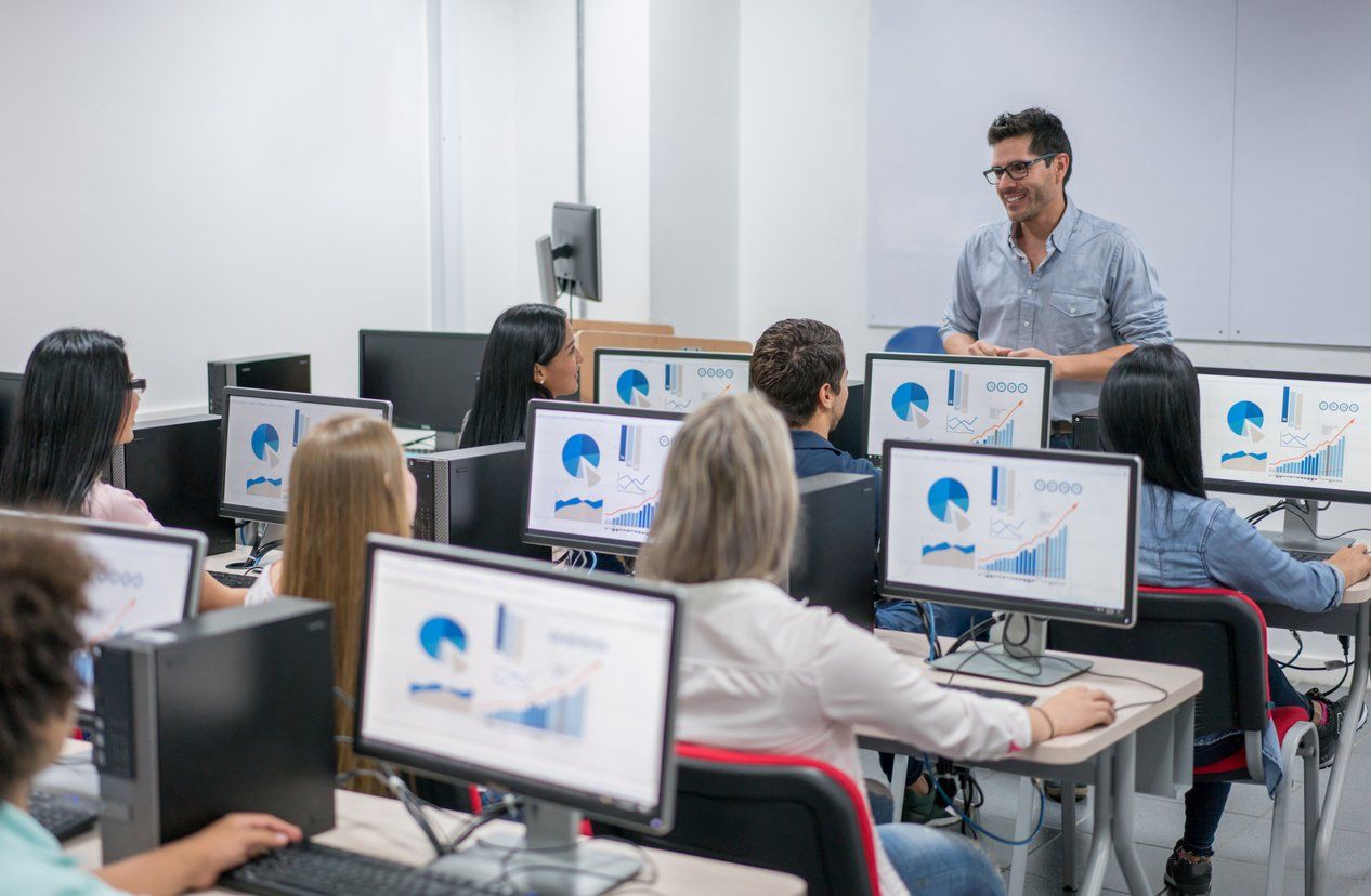 Teacher in a classroom teaching an IT class.