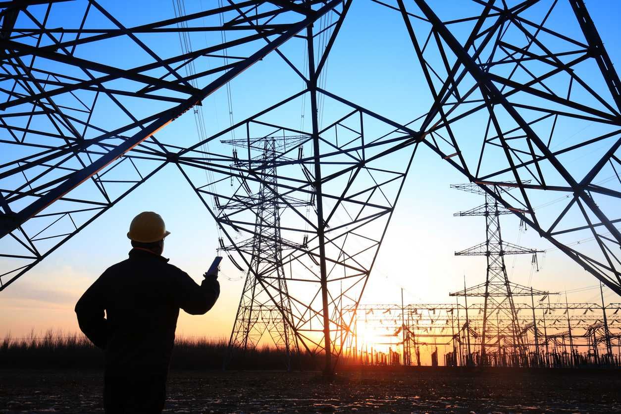 photo of electricity workers and pylon silhouette
