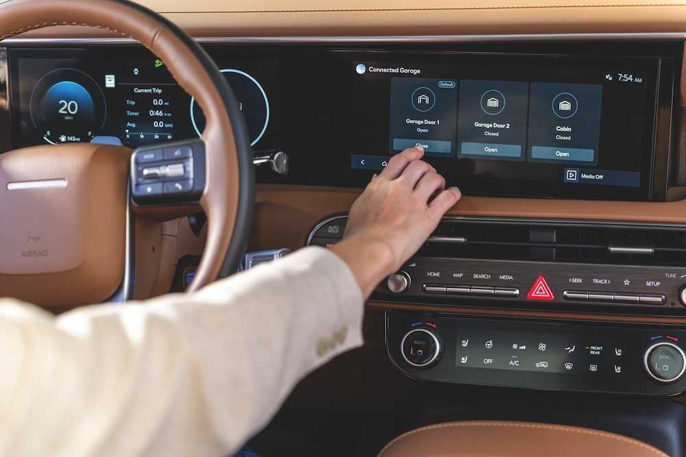 a photo of a woman interacting with myQ on her Hyundai's dashboard