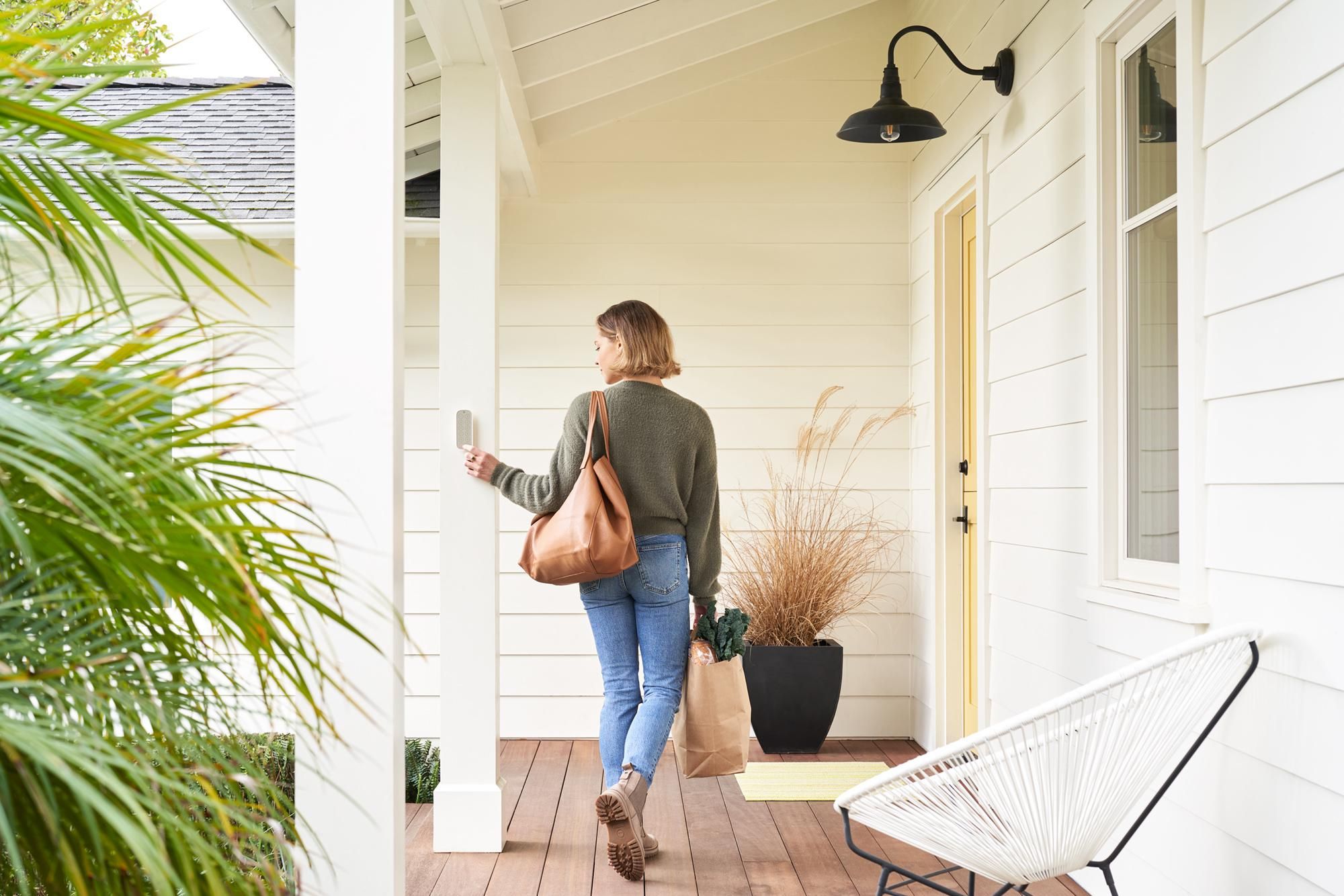 Woman Using Level Keypad to unlock her Level Lock on her front door.