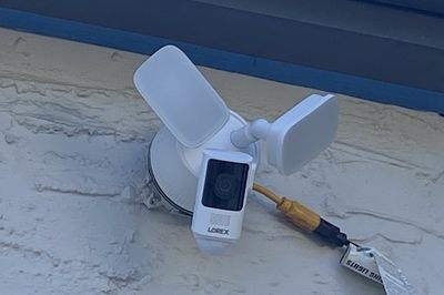 a photo of Lorex 2K wired Floodlight Security Camera on the side of a home.