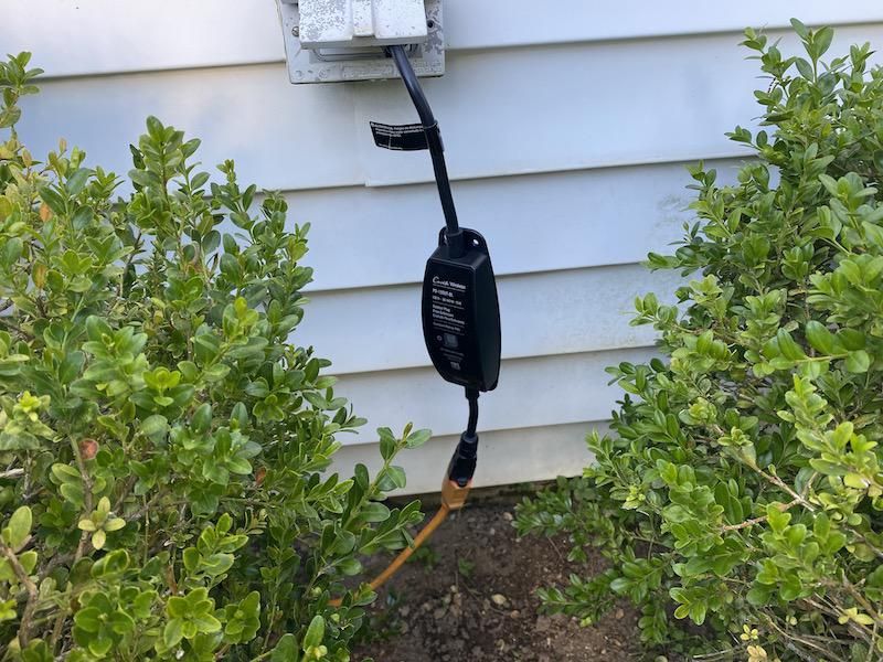 Lutron Caseta Outdoor Smart Plug plugged in an outdoor outlet.