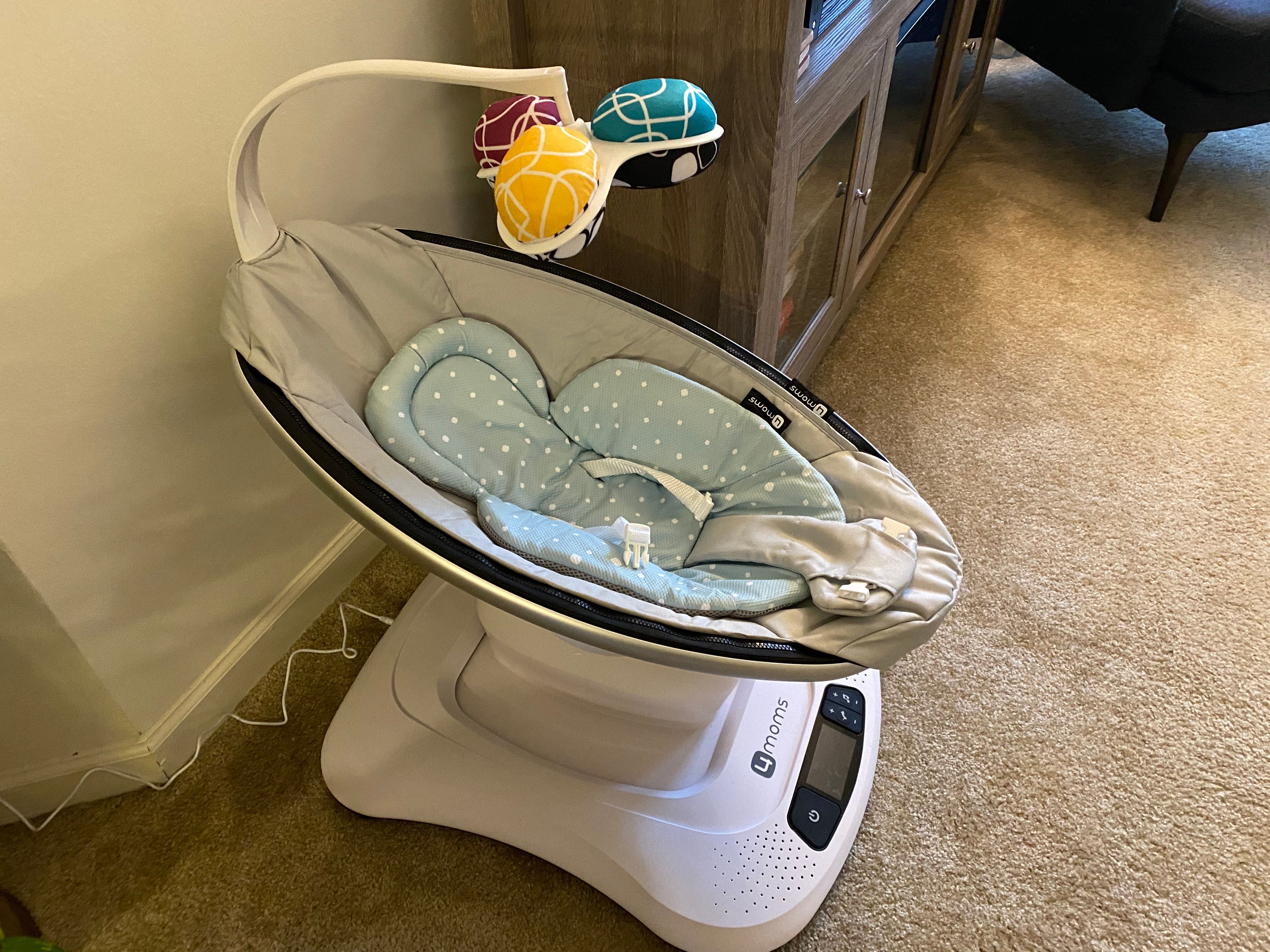 mamaRoo4 with infant insert and mobile plugged into the wall.