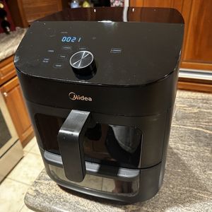 a photo of Midea Two-Zone 11QT Air Fryer Oven cooking on a countertop in a kitchen