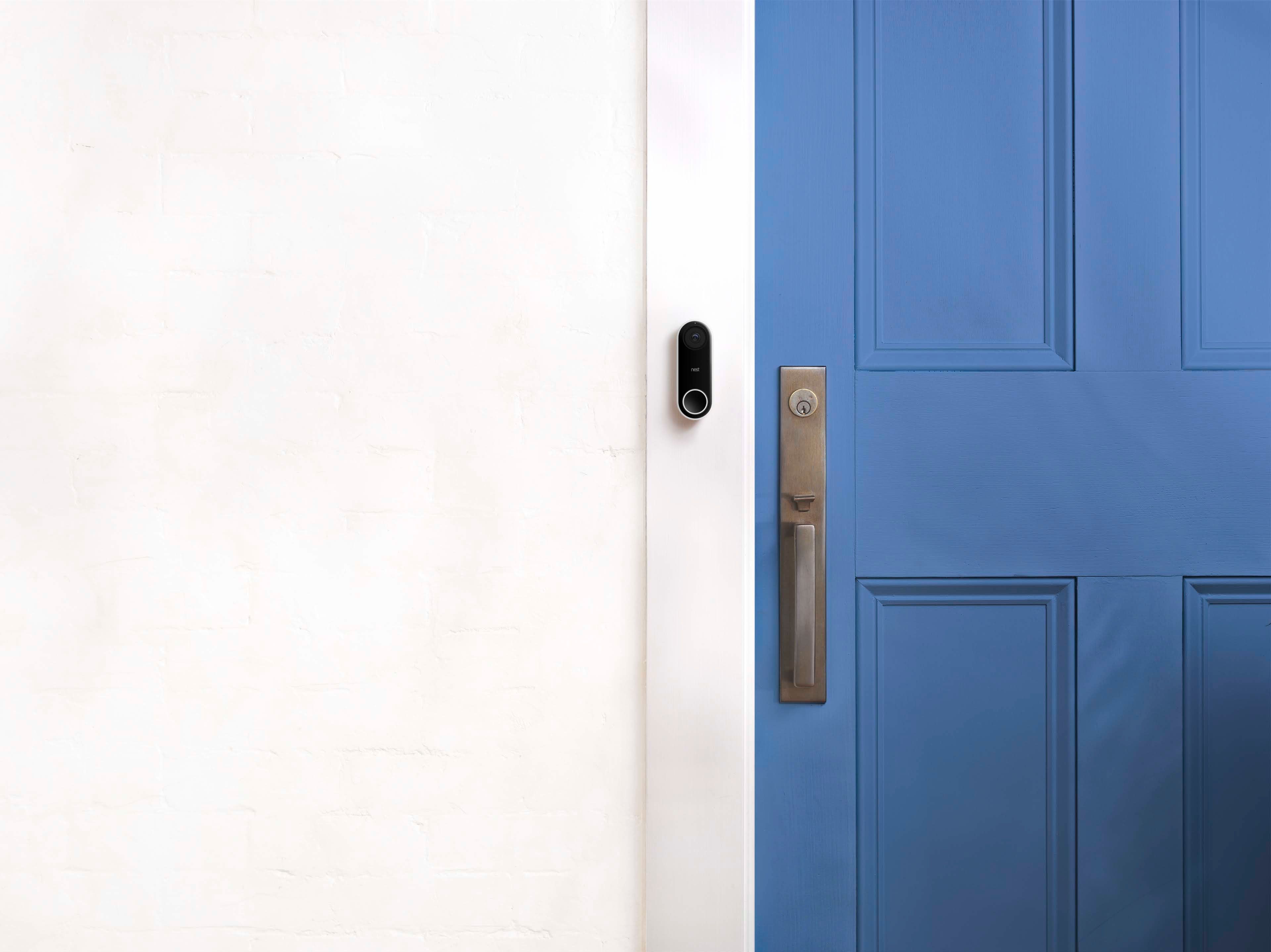 Blue door with a vide camera to the left on a white wall