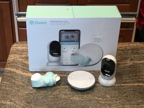 Owlet Sock and cam in the box on a counter.